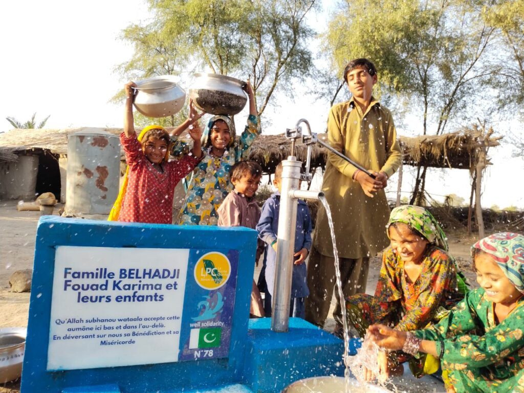 Enfants heureux autour d'un puits, village rural.