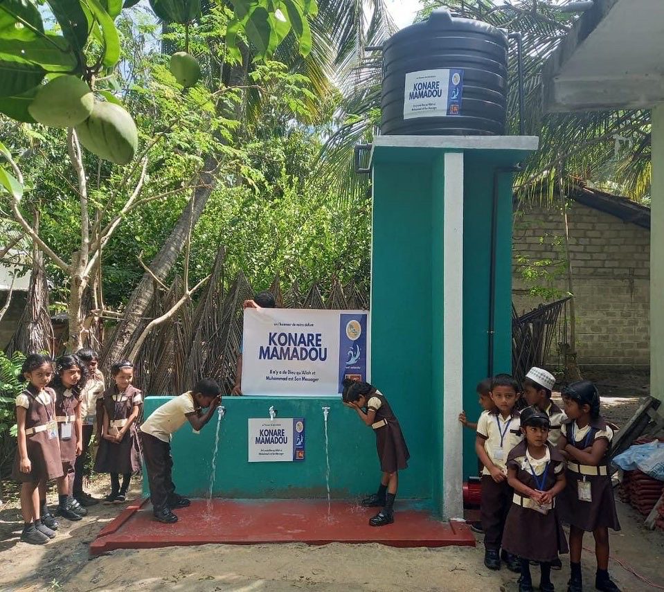 Enfants buvant d'une fontaine d'eau.