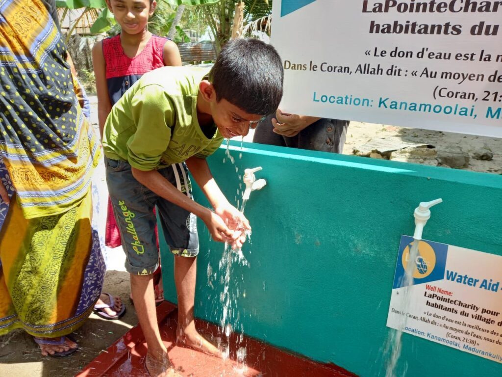 Enfant se lavant les mains à un robinet.