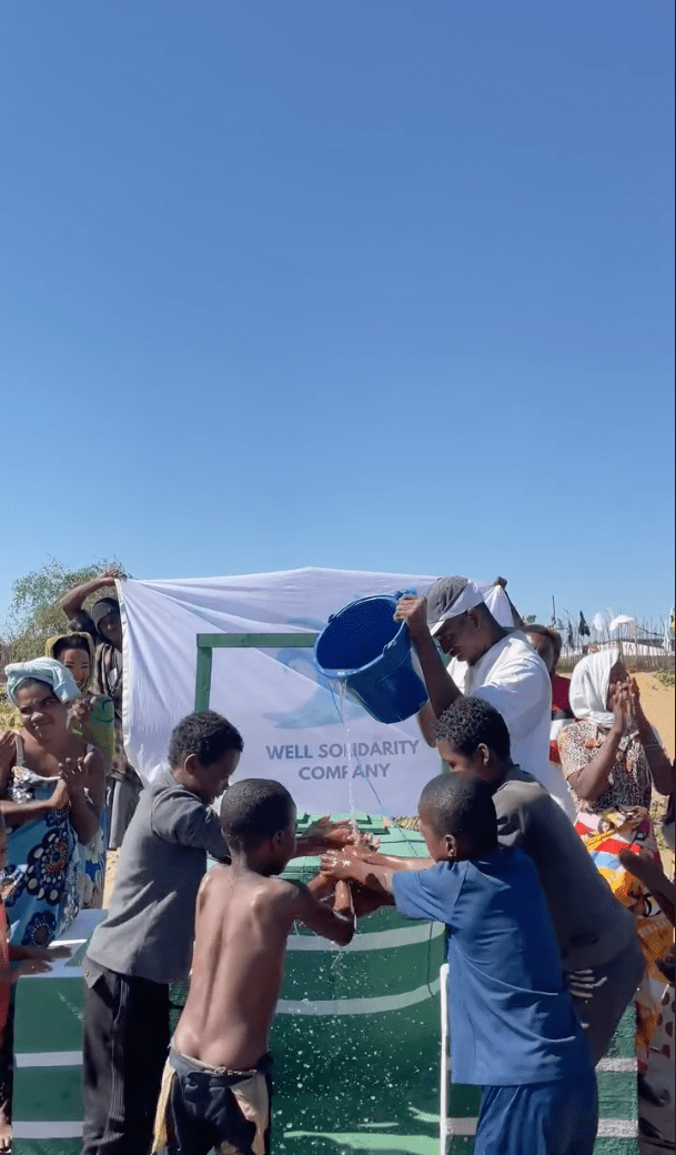 Personnes se lavent les mains au puit solidaire.