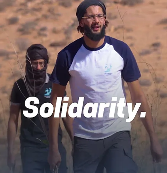 Deux hommes marchant dans le désert avec solidarité.