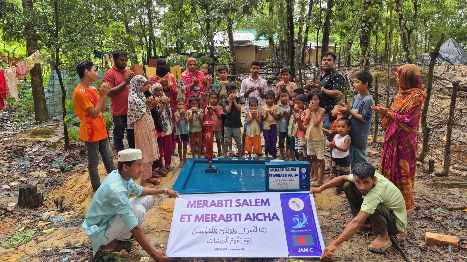Groupe de personnes autour d'une pompe à eau.
