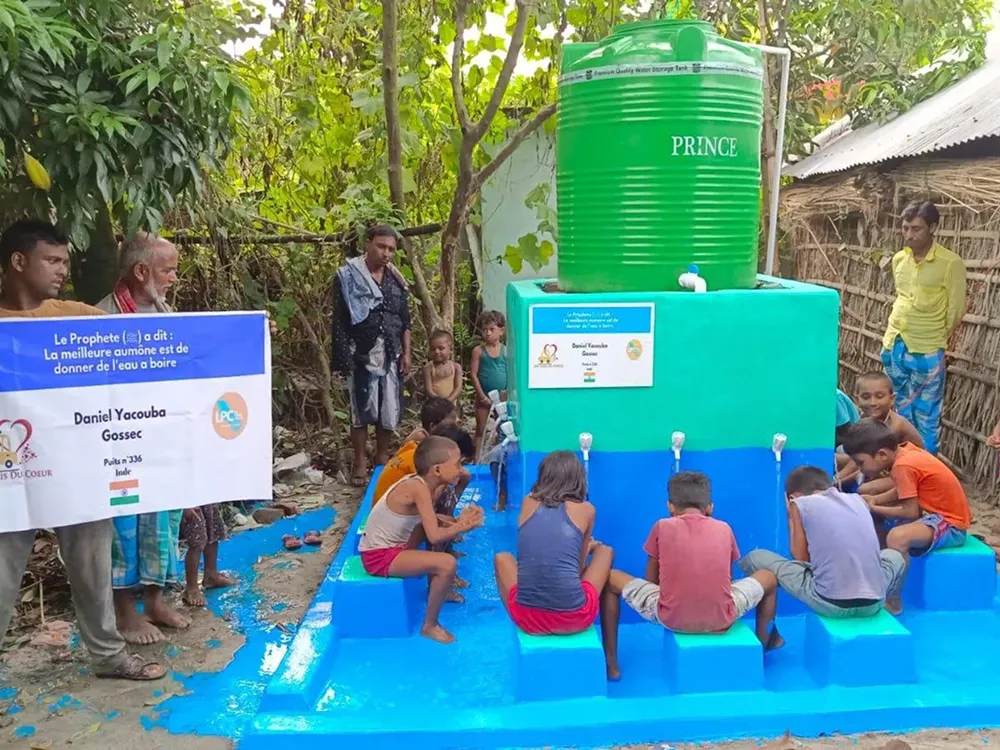 Enfants buvant à une fontaine communautaire.