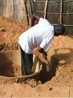 Personne creusant terre avec une pelle.