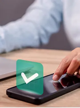 Main touchant smartphone avec icône de vérification.